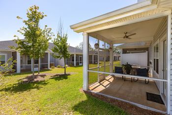a patio with a table and chairs under a porch